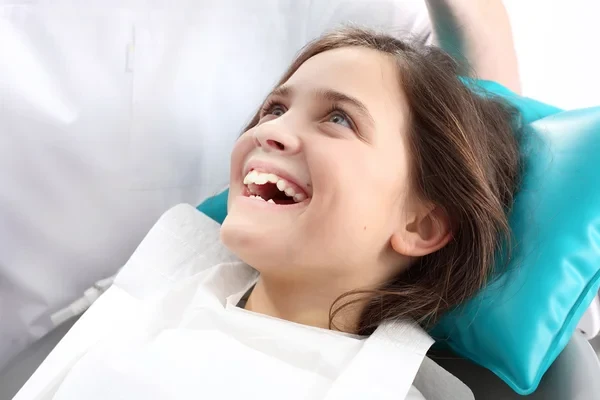 A girl on dental chair smiling