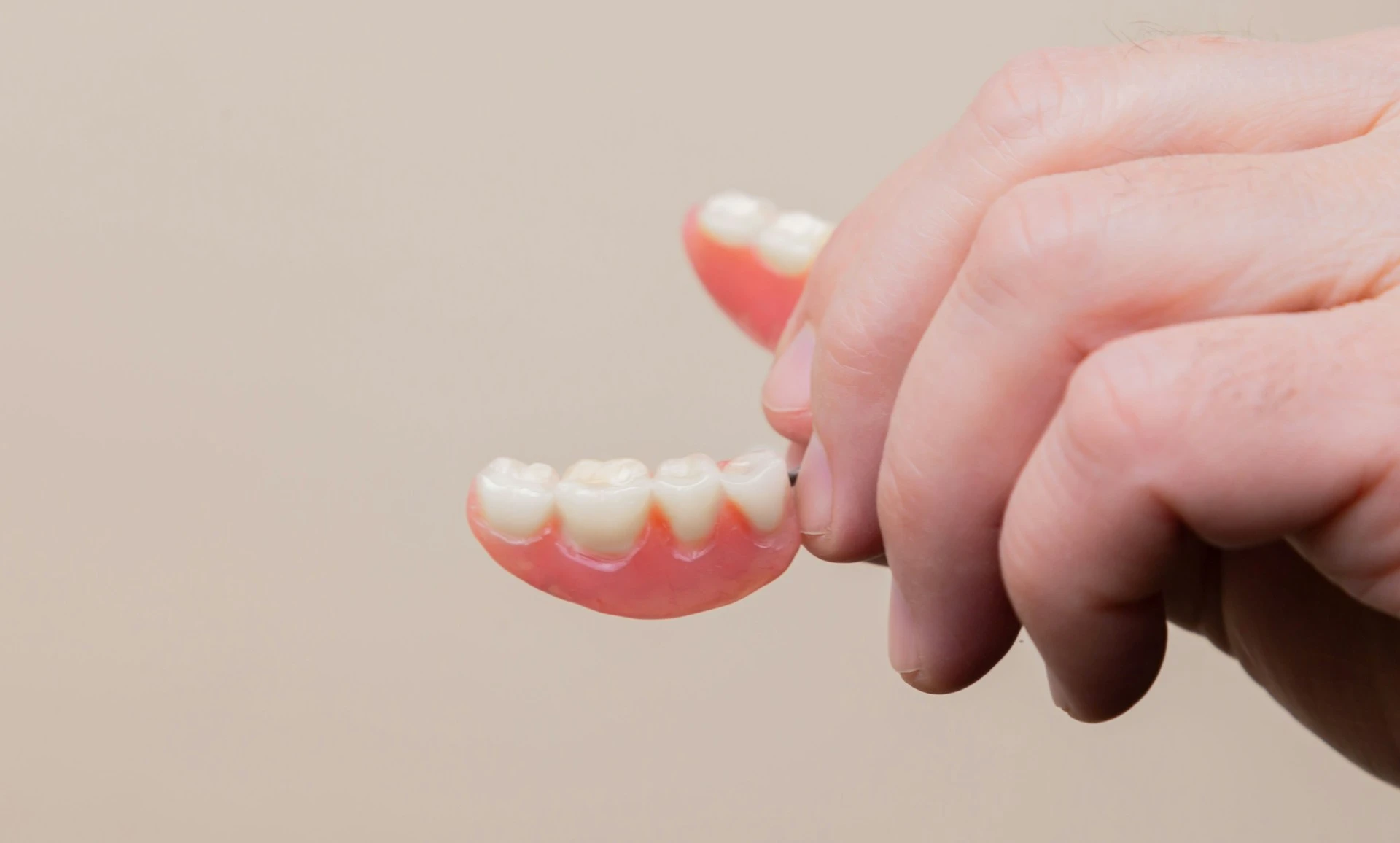 A man holds his denture