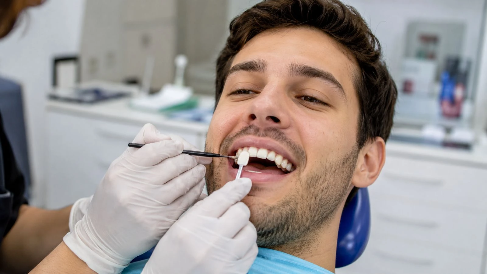 Close-up of a dentist performing a dental tooth shade selection for a cosmetic restoration
