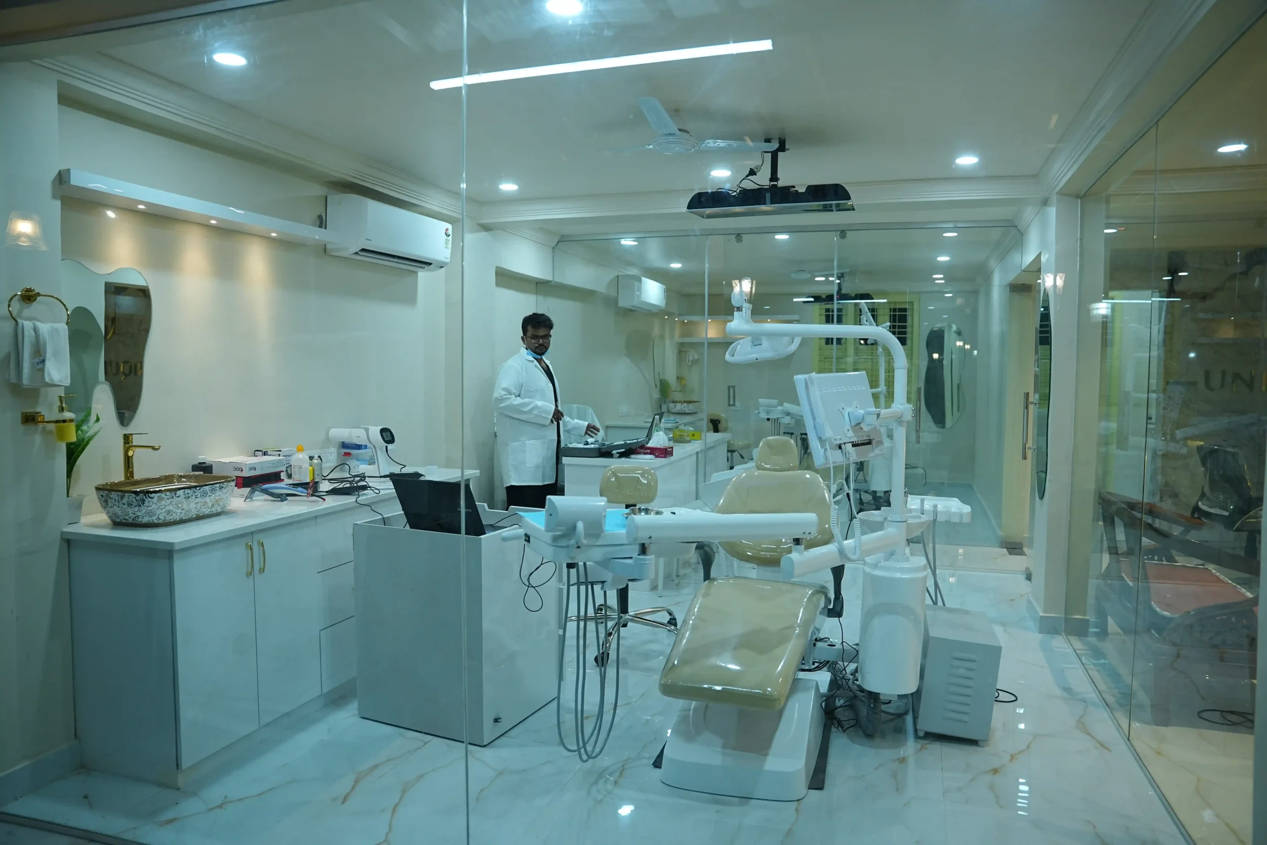 Dr. Rahmath standing inside a modern, fully equipped dental treatment room at Unique Dental Moula Ali clinic.