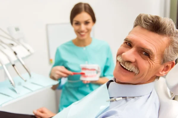 Elderly man in a dentist's chair smiling