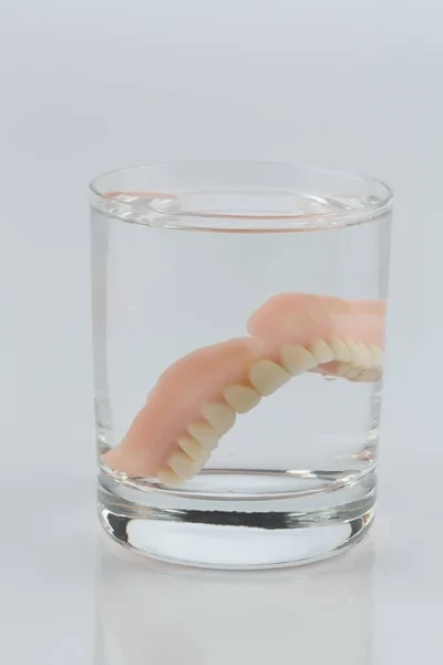 Removeable denture in a glass of water