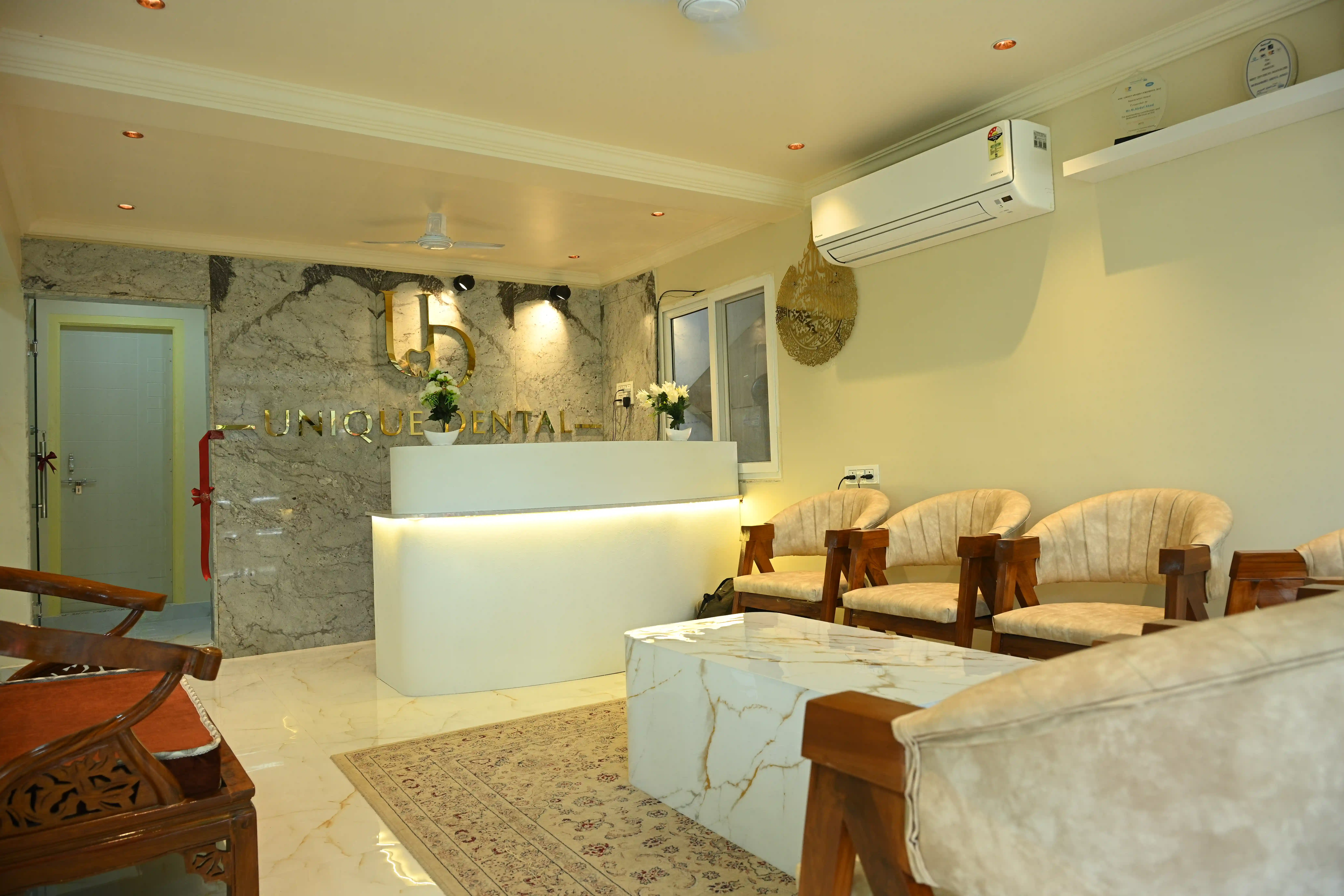 Patient waiting area and modern backlit reception counter at Unique Dental clinic in Moula Ali.