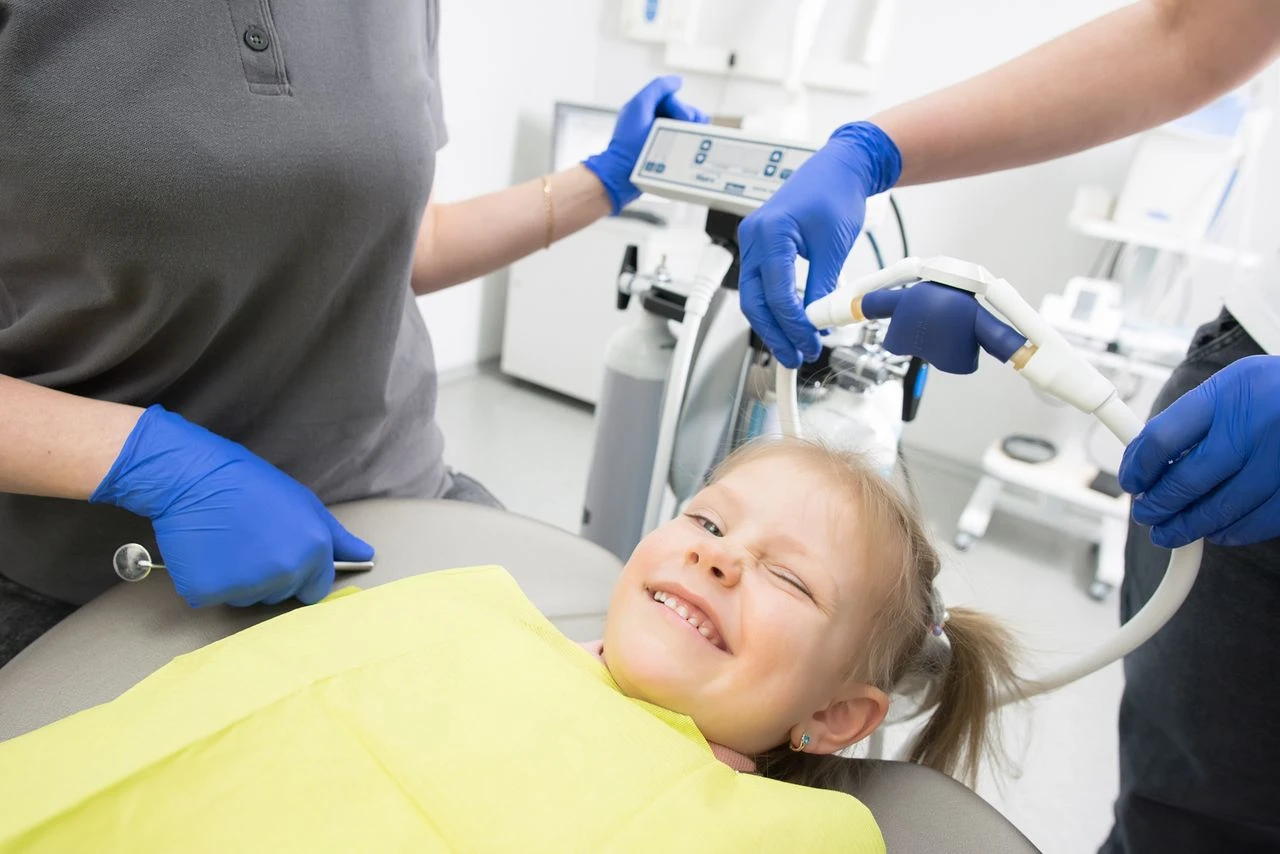 Young girl smiling sitting on a dental chair